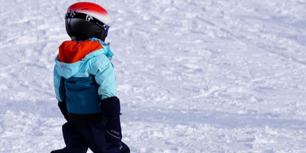 Un bambino preso di schiena sulla pista da scii