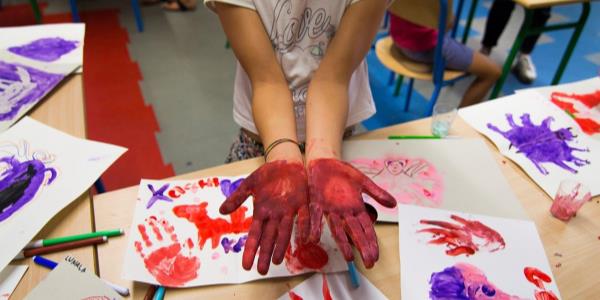 Bambino con le mani dipinte e i disegni